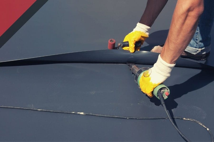 A man fixing a roof in daylight. Peachtree City GA Roofer - Commercial Roof Coatings Sure Thing Roofing Contractor