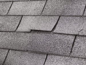  Damaged asphalt shingles on a roof in Peachtree City, GA showing a gap