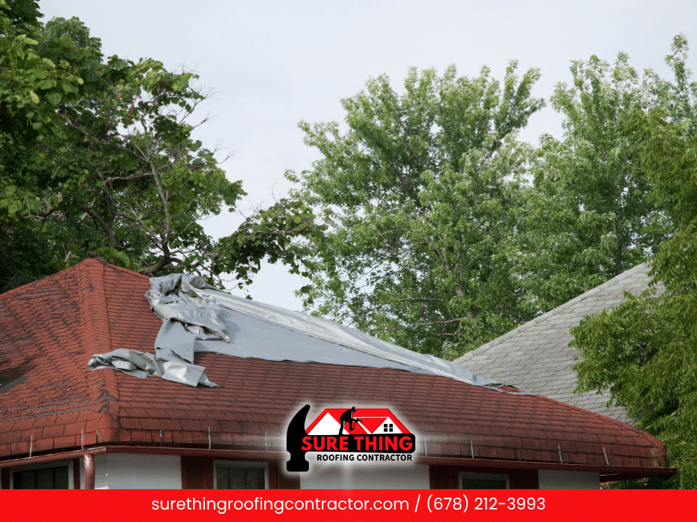 Roof with a tarp covering storm damage in Peachtree City, GA.
